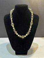 Front view of the necklace displayed on a black bust showing the alternating bead pattern and clasp.