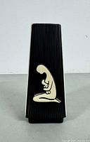 Front view of black ribbed side with cream-colored stylized kneeling woman holding a baby motif.