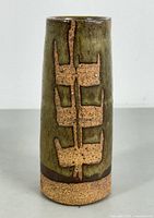 Front view of the cylindrical art pottery vase showing brown raised geometric textured design on olive green glazed background with rough-textured base.