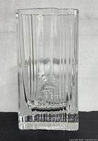 Clear glass vase with vertical ridges and irregular top edge from front view
