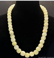 Necklace on black bust showing bead color and details.