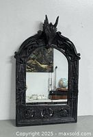 Front view of the full mirror leaning against a wall on a gray floor.