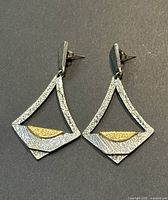 Front view of pair of vintage signed Darveau brutalist pewter earrings showing textured surface and gold-toned accent