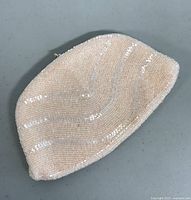 Front view of the cream and light pink beaded vintage clutch with wave pattern.