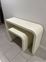 Vanity table and stool nested, showing size and curved edges.
