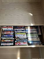 Top-down photo of a drawer with stacked DVD and Blu-ray cases featuring various titles and genres