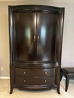 Front view of full armoire with doors closed and two pull-out drawers visible at bottom.
