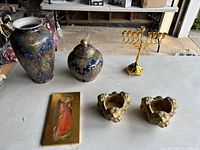 Full view of assorted knickknacks showing vase, covered jar, menorah, candle holders, and angel plaque