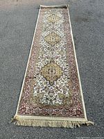Full length view of carpet runner laid flat displaying overall pattern and fringed edges.