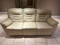 Front view of three-seat cream leather couch in upright position