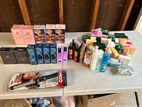 Overall lot overview with perfumes, hair products, soap and curling wand