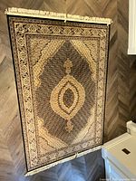 Full view of Solo Collection carpet displaying central intricate medallion and border pattern in black and creme.