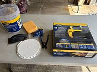 Overview of the tile installation kit on a table showing all included tools and items visually.