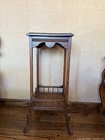 Front view of antique wooden Victorian Eastlake plant or display stand pedestal with detailed decorative elements and curved legs.