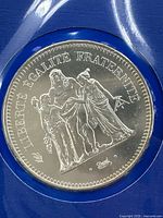 Obverse side of the 50 Franc silver coin showing three human figures with the motto 'LIBERTE EGALITE FRATERNITE'.