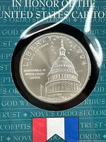 Close-up of commemorative silver dollar featuring United States Capitol building, with 1994 date and inscriptions.