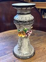 Full view of the gray ceramic vase with embossed design and floral decoration.