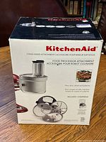 Photo of closed original KitchenAid food processor attachment box showing product image and branding, listing features like dice, slice, shred and julienne.