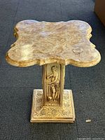 Overview photo showing marble top with ornate cut edges and decorative base.