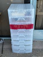 Plastic 8-drawer storage organizer with clear and red drawers, shown standing approximately 40 inches tall.