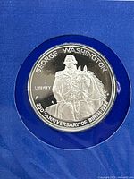 Close-up of proof silver half dollar coin featuring George Washington on horseback, commemorating 250th anniversary of birth 1982.