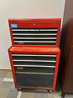 Full front view of red Sears Craftsman tool box with multiple drawers and sections, showing locking mechanism on bottom drawer.