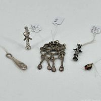 Overview of all six sterling silver charms on a white background showing variety and relative sizes.