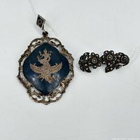 Photo showing both sterling silver pendant with blue enamel deity and floral marcasite pin