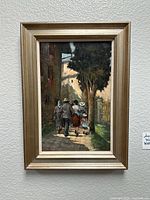 Framed vertical oil painting of four people walking along a cobblestone street under a tree, with sunlight casting shadows on the ground.