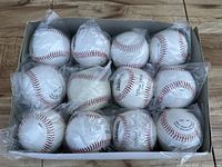 Box containing 12 individually wrapped white baseballs with red stitching.