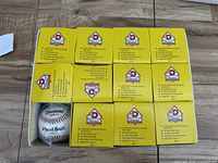 Set of 12 yellow boxed Diamond Plexi Ball baseballs stacked in three rows of four boxes each, one box open showing a ball inside.