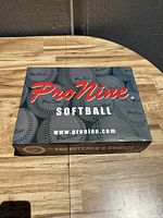 Closed box of Pro Nine softballs with branding and website visible
