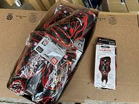 Packaged group of black and red youth soccer protective gear including shin guards and elbow guards.