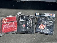All 3 equipment bags together in clear plastic packaging showing brand logos and colors.