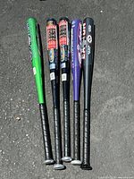 Five aluminum baseball bats aligned side by side showing full length and grip tape details on handle ends.