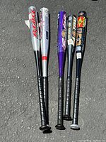 Photo of the full length of all 5 aluminum baseball bats arranged side by side on paved surface, showing brands and colors.