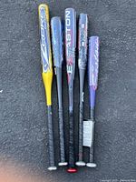 Top view of all 5 aluminum baseball bats showing color and design variation