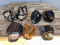 All 8 gloves laid out on a table showing overall condition, color variations, and mixed sizes.