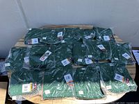 Picture showing all Wilson henley t-shirts arranged on a table, individually packaged in clear plastic with labels visible.