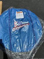 Blue collapsible net with label Instant Goooal shown in folded state inside plastic wrap