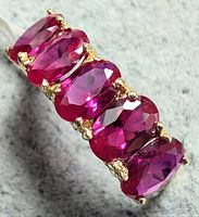 Angled view of lab-grown rubies alignment on yellow gold band