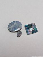 Three genuine opal triplet stones in different shapes and colors on a white background.