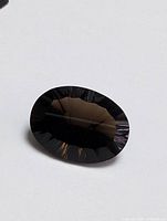 Front angle showing the deep brown-black color and faceted cut of the oval Smokey Quartz gemstone.