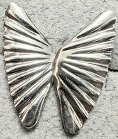 Front view of one silver butterfly wing-shaped earring showing ribbed design and polished finish on gray background.