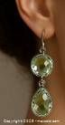 The first image shows one silver dangle earring worn on a human ear, focusing on round and pear-shaped faceted green amethyst gemstones.