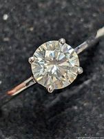 Close-up photo of the silver ring with a round 1.08ct moissanite stone showing the detail of the prong setting and facets.