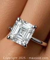 Close-up photo of a silver ring with a square-shaped clear moissanite stone set in four prongs on a finger.