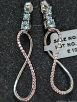 Close-up of the pair of sterling silver earrings with blue topaz stones and clear stones on front loop