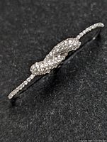 Top detailed close-up of the sterling silver two-finger ring showing cluster of small clear crystals on curved top surface.