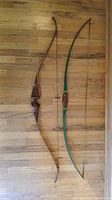 Both recurve bows full length on wood floor